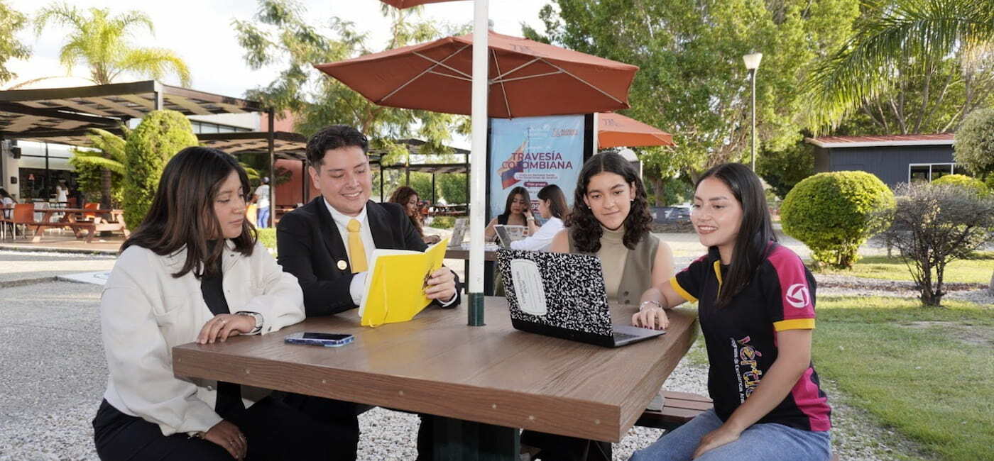 Estudiantes de la Universidad Anáhuac Oaxaca sentados en inmobiliario del campus colaborando juntos