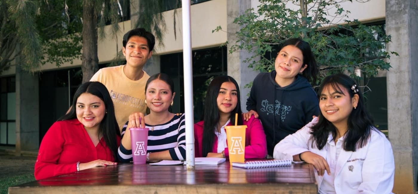 Grupo de estudiantes universitarios en campus de Oaxaca, compartiendo experiencias y preparándose para su primer año académico.