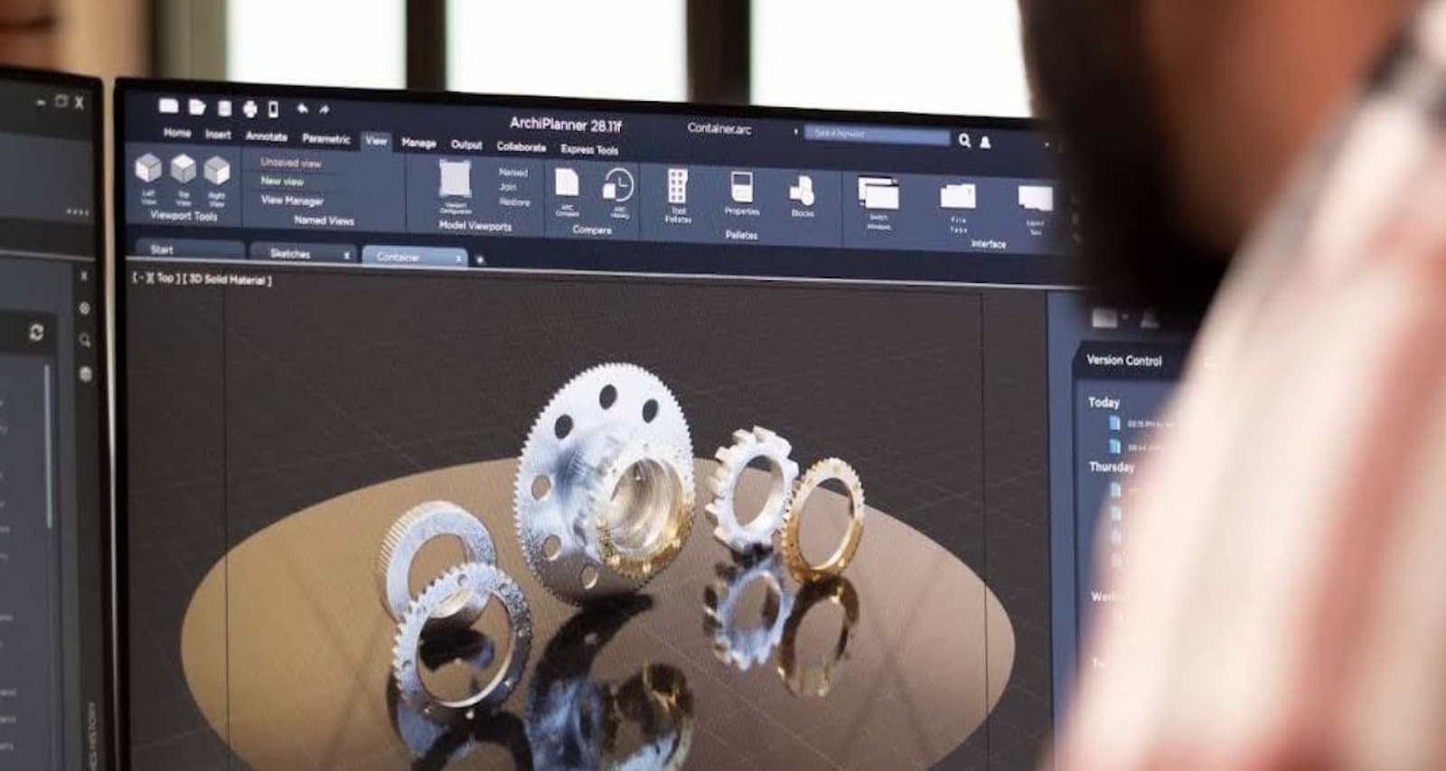 Estudiante de diseño industrial sentado renderizando engranajes en un CAD